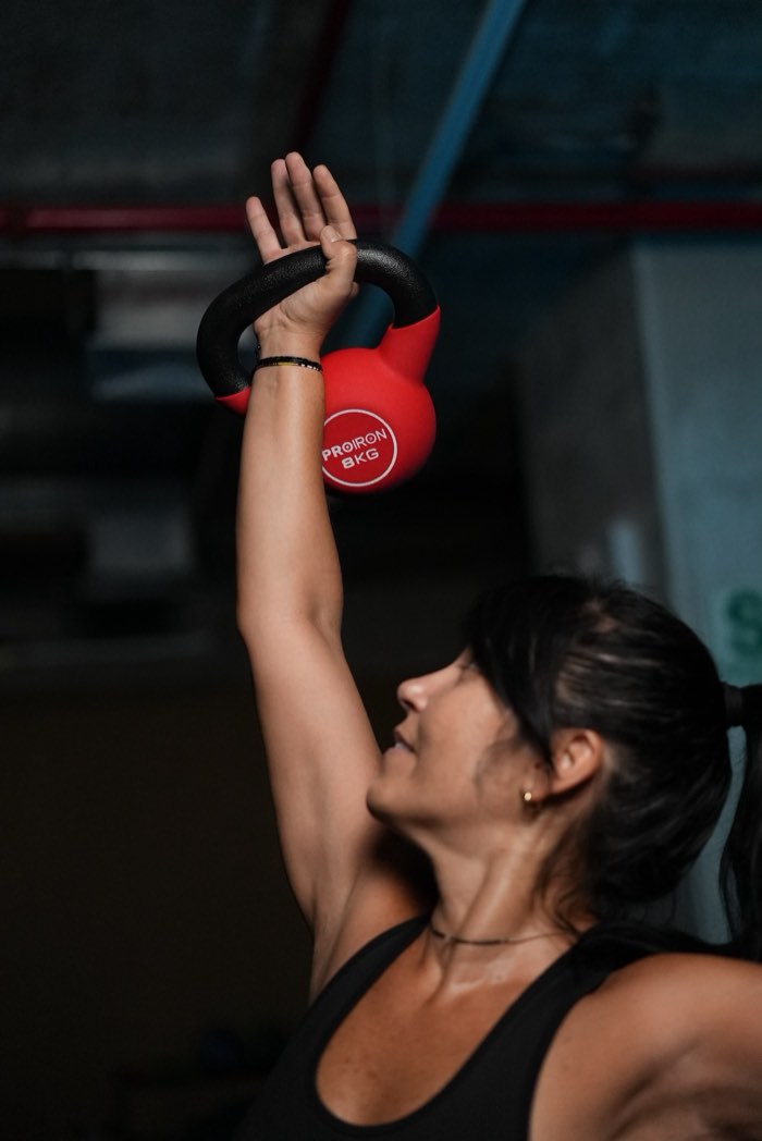 Karla Dellepiane presionando un kettlebell